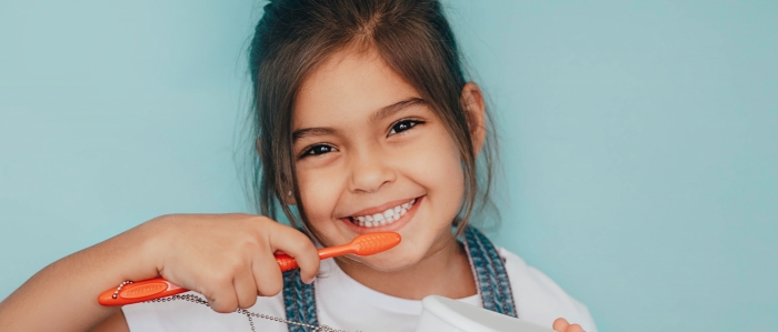 smiling young girl brushing teeth