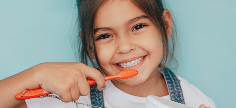 smiling young girl brushing teeth