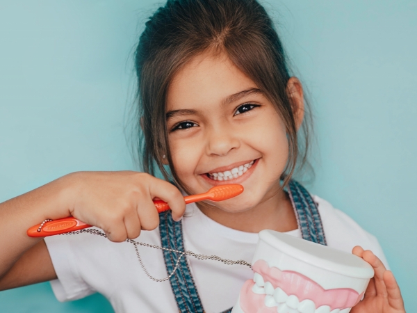 smiling young girl brushing teeth