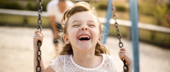 little girl smiling on swing