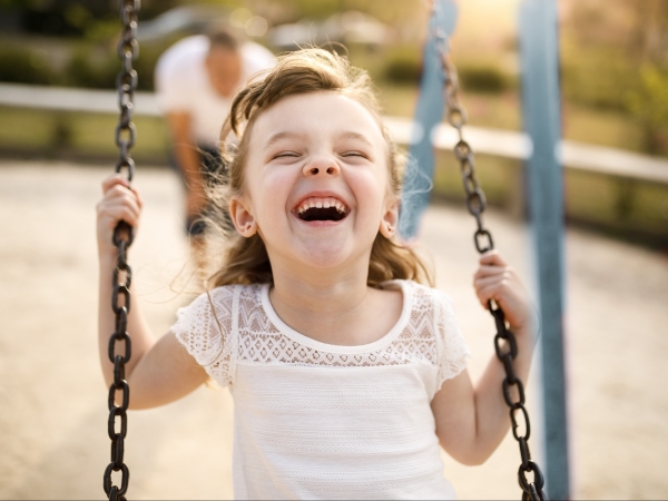 little girl smiling on swing