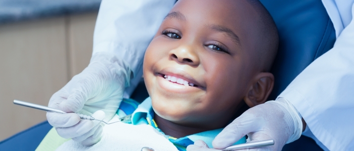 young boy smiling as the dentist waits to examine his mouth with dental tools