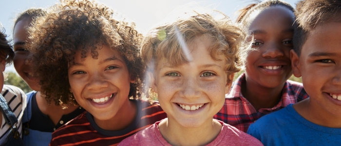 Group of kids smiling on a sunny day root canal Hudsonville MI pediatric dentist