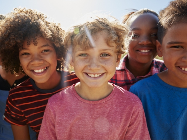 Group of kids smiling on a sunny day root canal Hudsonville MI pediatric dentist